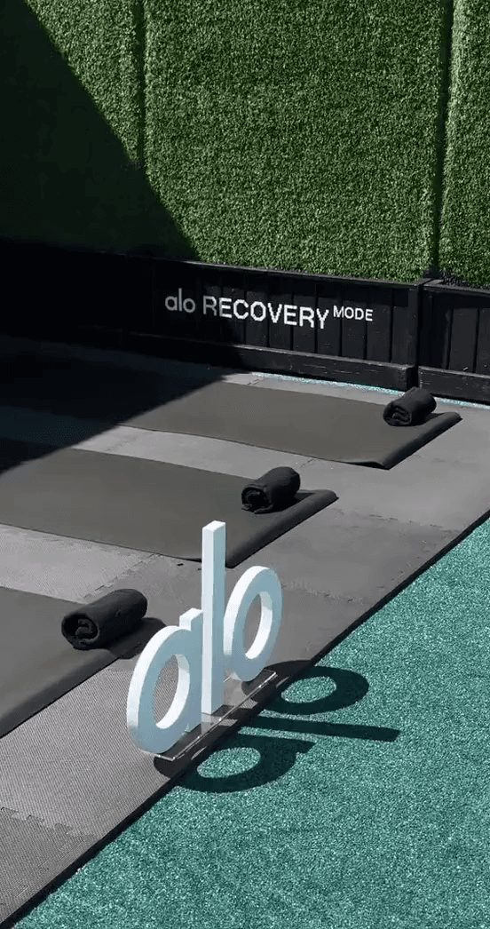An Alo Recovery Mode studio with yoga mats and a standing alo letter