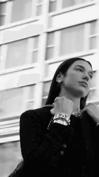 Chanel: a model in a black jacket by a stone facade