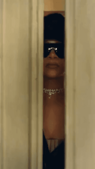 Dior: a woman in sunglasses glimpsed through a cracked door