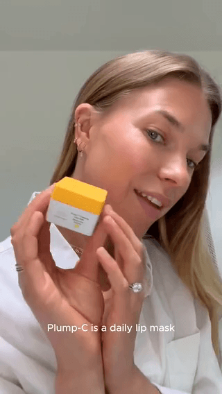 Drunk Elephant: a woman in a white coat holding a yellow-lid cream jar
