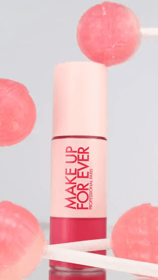 Make Up For Ever: a pink lip colour bottle among floating lollipops