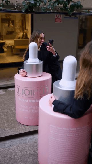 Clinique: oversized pink dropper bottles in a lobby