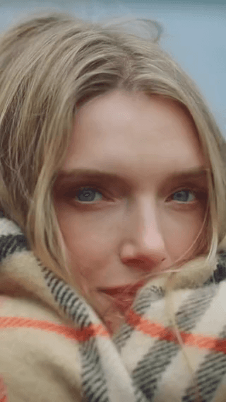 Burberry: a blonde woman wrapped in a plaid scarf